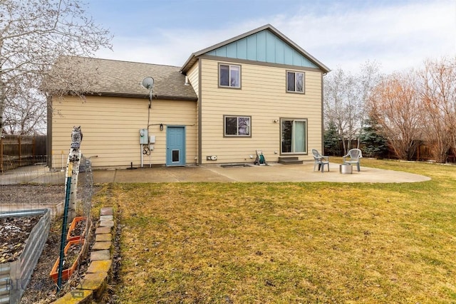 back of house featuring board and batten siding, a lawn, a patio, entry steps, and fence