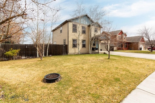 traditional-style house with driveway, fence, and a front lawn