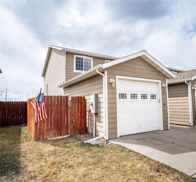 1112 Biehl Unit A, Belgrade, MT 59714 - view of property exterior featuring fence, a garage, and driveway