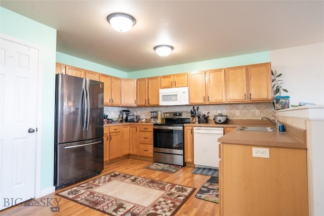 1112 Biehl Unit A, Belgrade, MT 59714 - kitchen with tasteful backsplash, light brown cabinets, a sink, light wood-type flooring, and appliances with stainless steel finishes