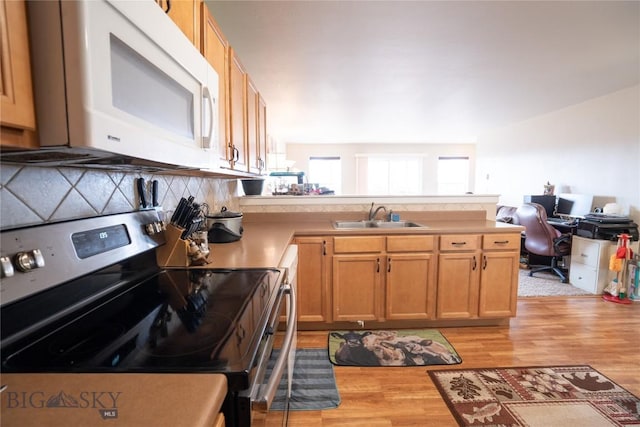 1112 Biehl Unit A, Belgrade, MT 59714 - kitchen featuring white microwave, light wood-style flooring, a peninsula, stainless steel electric range oven, and a sink