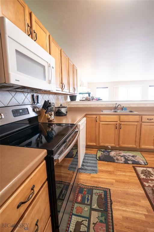 1112 Biehl Unit A, Belgrade, MT 59714 - kitchen with tasteful backsplash, white appliances, light countertops, and a sink