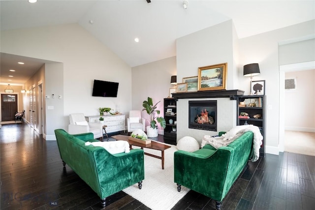 living room with recessed lighting, high vaulted ceiling, baseboards, a glass covered fireplace, and hardwood / wood-style flooring
