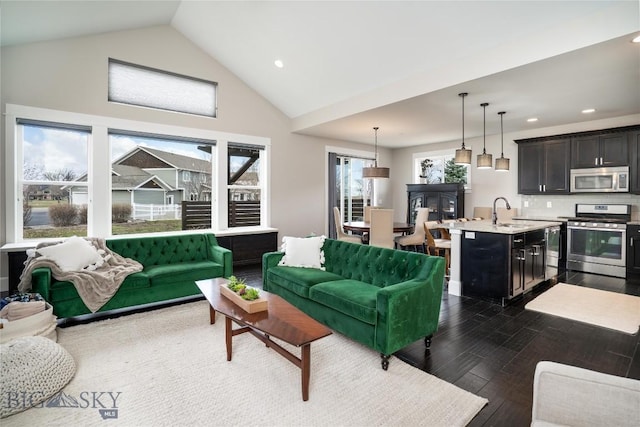 living area featuring recessed lighting, dark wood finished floors, and high vaulted ceiling