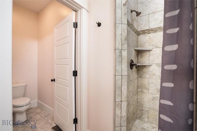 full bathroom with a tile shower, toilet, and baseboards