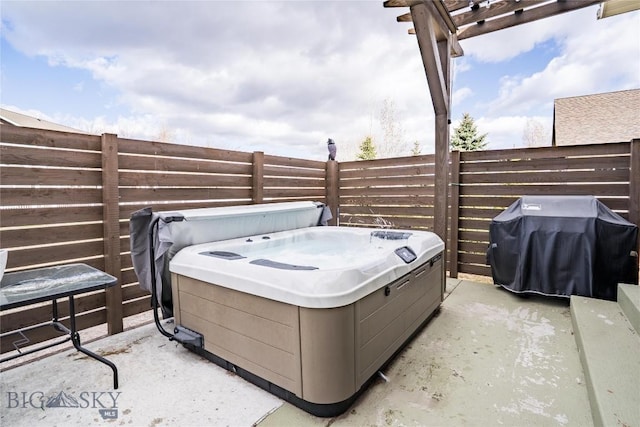 view of patio featuring fence, a hot tub, and area for grilling