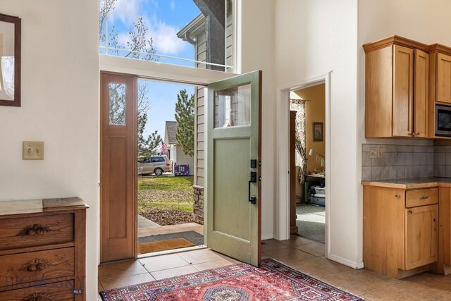 2514 Putter Ct, Bozeman, MT 59715 - entrance foyer featuring light tile patterned floors, a towering ceiling, and baseboards