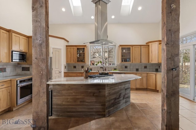 2514 Putter Ct, Bozeman, MT 59715 - kitchen featuring backsplash, a skylight, island exhaust hood, and stainless steel appliances