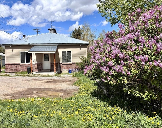 521 E Bannack St, Dillon, MT 59725 - view of front of house featuring brick siding and a chimney