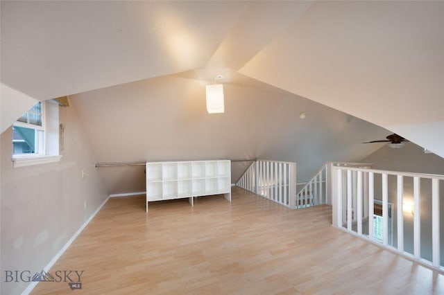 additional living space featuring wood finished floors, baseboards, and vaulted ceiling