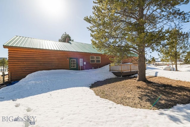 1319 Mcclellan, West Yellowstone, MT 59758 - snow covered property with a deck, faux log siding, and a metal roof