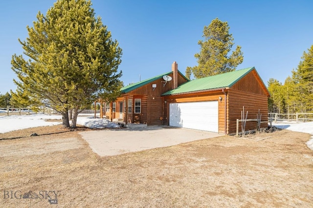 1319 Mcclellan, West Yellowstone, MT 59758 - view of front facade with a garage and a metal roof