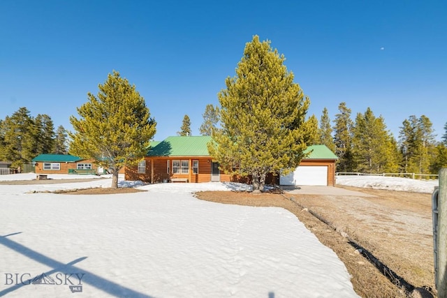1319 Mcclellan, West Yellowstone, MT 59758 - view of front of property featuring a garage, driveway, and a metal roof
