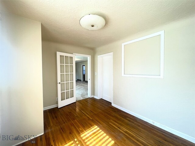 415 E Geyser, Livingston, MT 59047 - empty room with french doors, baseboards, wood finished floors, and a textured ceiling