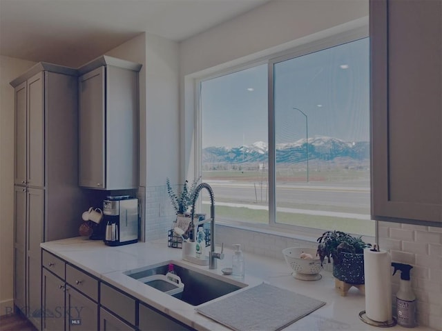 1823 N Cottonwood Rd, Bozeman, MT 59718 - kitchen featuring backsplash, a sink, light stone countertops, and gray cabinetry