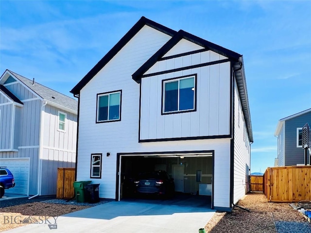 1823 N Cottonwood Rd, Bozeman, MT 59718 - view of front facade with board and batten siding, an attached garage, fence, and concrete driveway