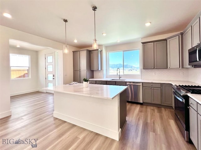1823 N Cottonwood Rd, Bozeman, MT 59718 - kitchen featuring stainless steel appliances, gray cabinets, backsplash, light wood-type flooring, and recessed lighting