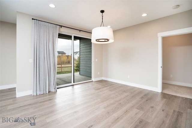 unfurnished dining area with baseboards, recessed lighting, and wood finished floors
