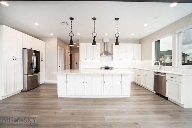 1610 Windrow Dr, Bozeman, MT 59718 - kitchen with stainless steel appliances, wall chimney range hood, a center island, white cabinetry, and recessed lighting
