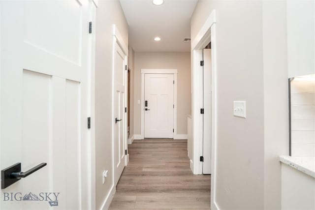 hall featuring visible vents, light wood-style flooring, recessed lighting, and baseboards