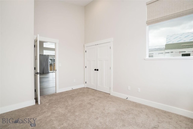 1610 Windrow Dr, Bozeman, MT 59718 - unfurnished bedroom featuring carpet, a high ceiling, and baseboards