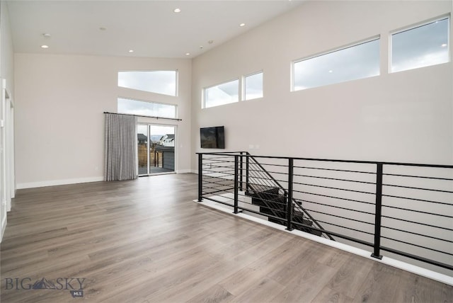 1610 Windrow Dr, Bozeman, MT 59718 - unfurnished room featuring wood finished floors, baseboards, a towering ceiling, and recessed lighting