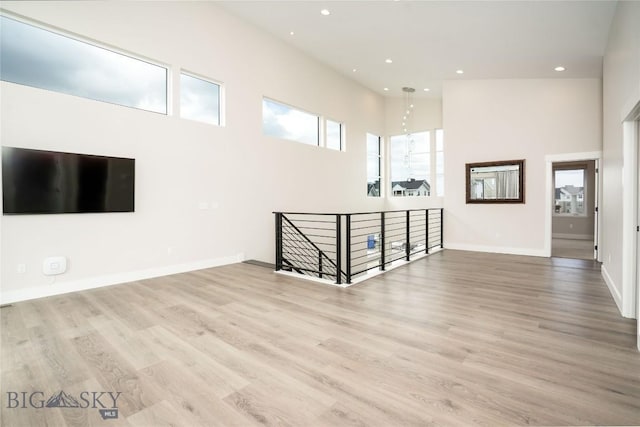 1610 Windrow Dr, Bozeman, MT 59718 - unfurnished living room with a high ceiling, recessed lighting, wood finished floors, and baseboards