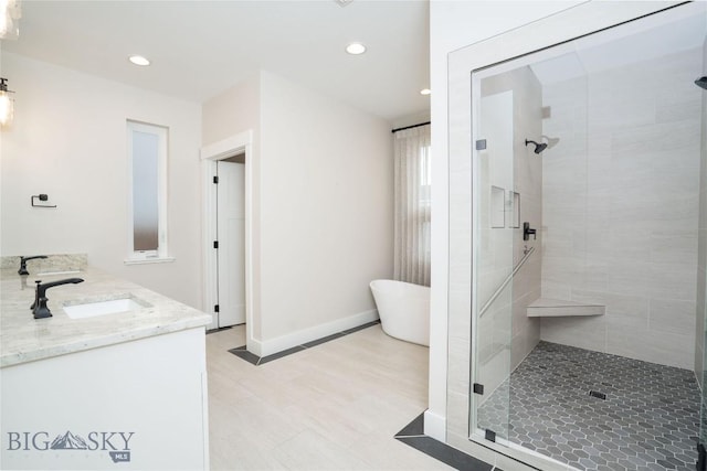 1610 Windrow Dr, Bozeman, MT 59718 - full bathroom featuring a stall shower, a freestanding bath, double vanity, recessed lighting, and baseboards