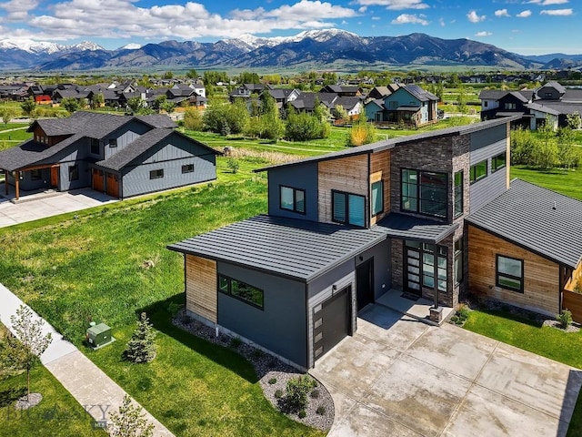 1610 Windrow Dr, Bozeman, MT 59718 - view of front facade featuring a residential view, stone siding, an attached garage, driveway, and a mountain view