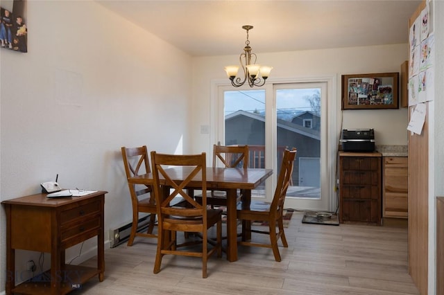 dining area with a baseboard radiator, a chandelier, and light wood-style flooring