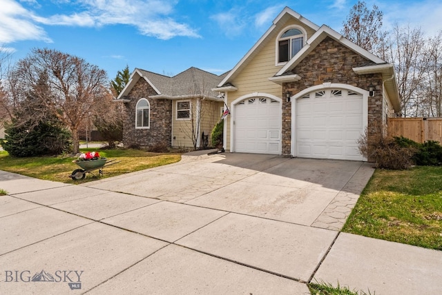 single story home with fence, an attached garage, driveway, stone siding, and a front yard