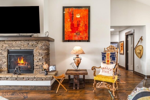 living area with a fireplace, wood finished floors, and baseboards