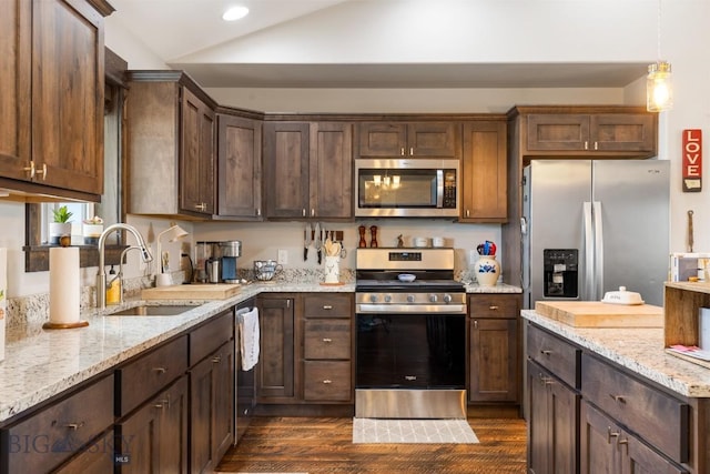 kitchen with a sink, dark wood-style flooring, dark brown cabinetry, lofted ceiling, and appliances with stainless steel finishes
