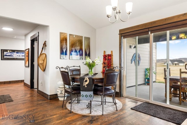 dining area featuring baseboards, vaulted ceiling, wood finished floors, and an inviting chandelier