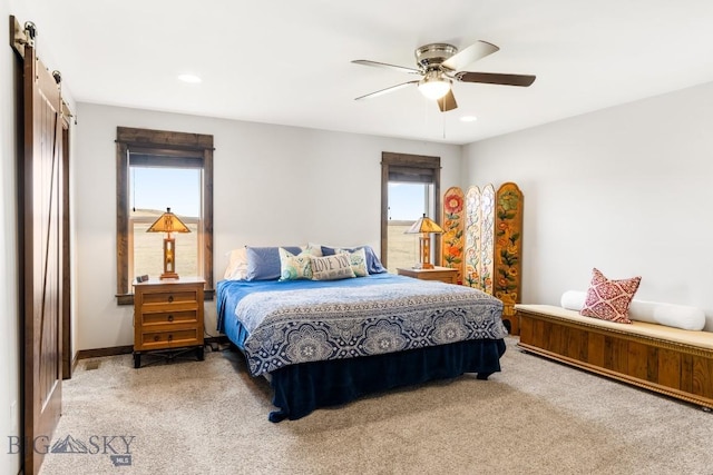 carpeted bedroom with a barn door, a ceiling fan, and recessed lighting