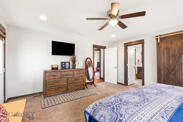 carpeted bedroom featuring recessed lighting, a barn door, ensuite bath, baseboards, and ceiling fan