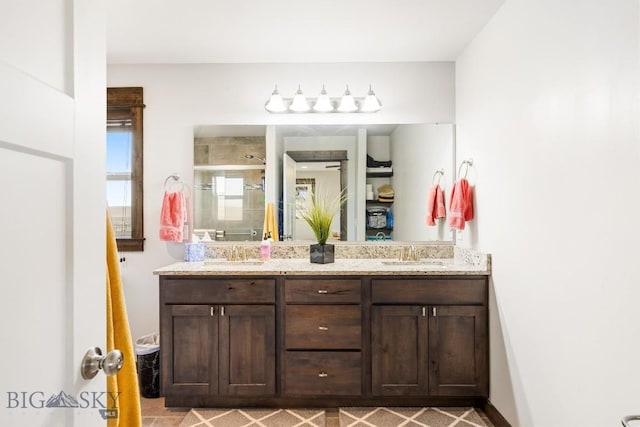 bathroom with a sink, double vanity, and a stall shower