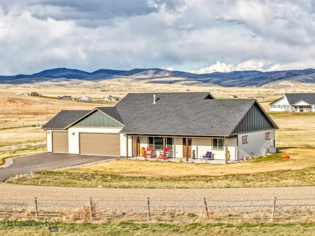 view of front of home featuring an attached garage, fence, board and batten siding, and covered porch