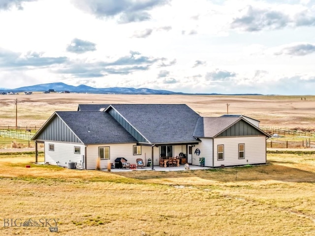 rear view of house featuring board and batten siding, cooling unit, a patio area, and fence