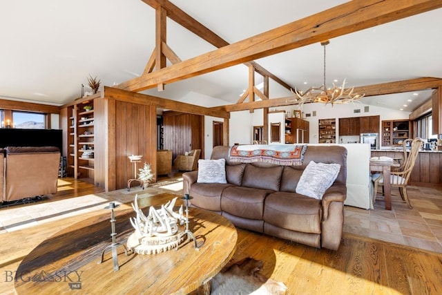 living area featuring light wood-style floors, beam ceiling, a notable chandelier, and high vaulted ceiling