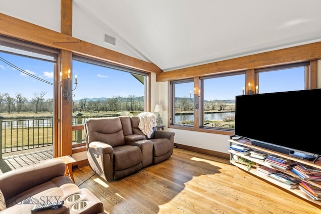 living room with lofted ceiling, wood finished floors, and baseboards