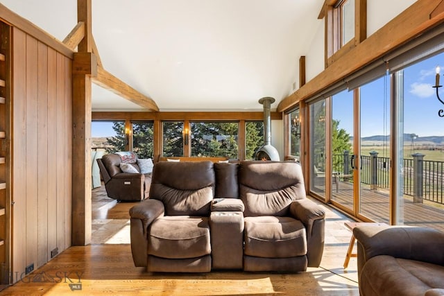 sunroom / solarium featuring a healthy amount of sunlight, a wood stove, and a mountain view
