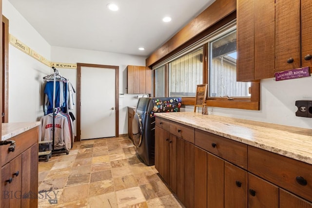 laundry room featuring recessed lighting, cabinet space, stone finish floor, and independent washer and dryer