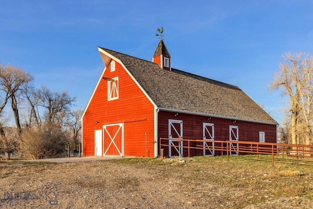 view of barn featuring fence