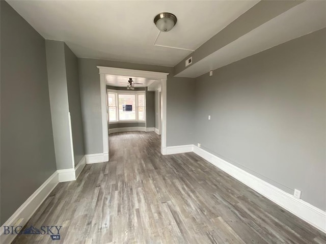 interior space featuring baseboards, wood finished floors, and visible vents