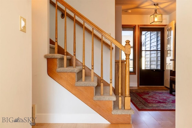 foyer entrance featuring baseboards and stairs