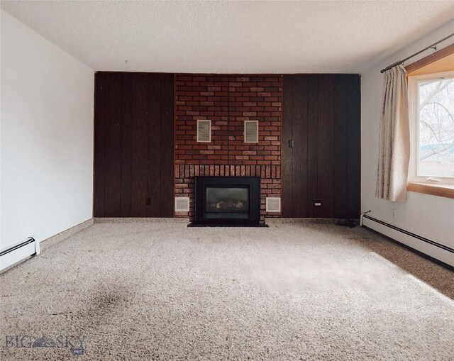 509 1st E, Whitehall, MT 59759 - unfurnished living room featuring a brick fireplace, wood walls, carpet, a textured ceiling, and a baseboard radiator