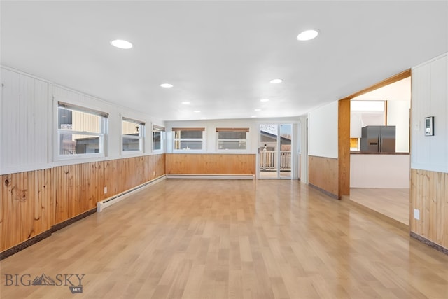 509 1st E, Whitehall, MT 59759 - spare room with light wood-type flooring, wooden walls, a baseboard radiator, wainscoting, and recessed lighting
