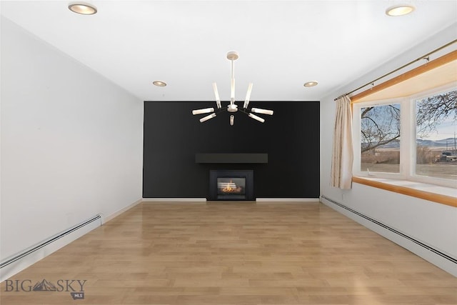 509 1st E, Whitehall, MT 59759 - unfurnished living room with baseboard heating, recessed lighting, light wood finished floors, a glass covered fireplace, and an accent wall