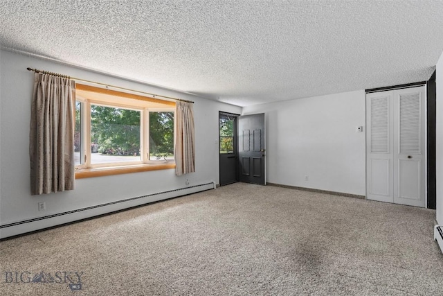 509 1st E, Whitehall, MT 59759 - unfurnished bedroom featuring baseboard heating, a textured ceiling, and carpet floors